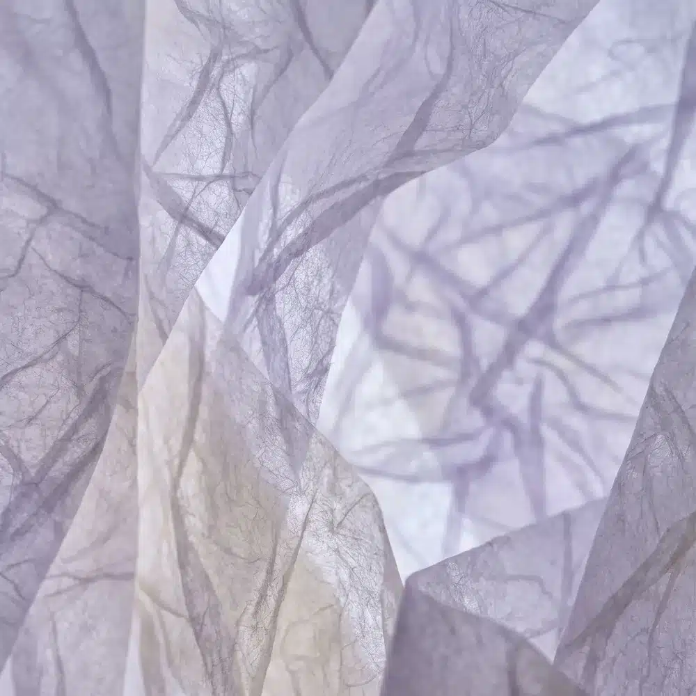 Plis de papier translucide lavande évoquant des ramifications